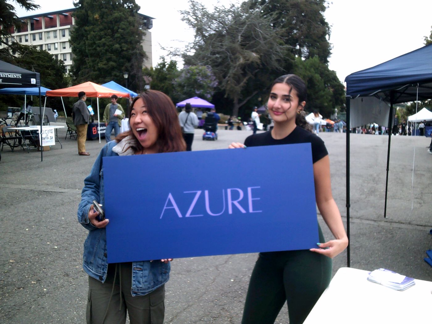 Two Azure members holding a blue AZURE sign at a campus club fair